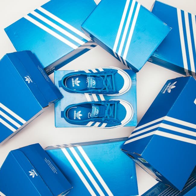 Blue Adidas shoes and boxes arranged in a stylish flat lay on a white background.