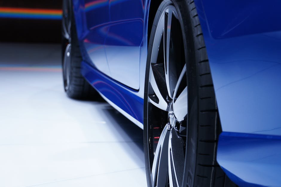 Close-up shot of a blue car highlighting the stylish alloy wheel. Perfect for automotive enthusiasts.