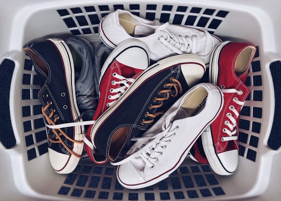 A variety of vintage sneakers piled in a white laundry basket. Perfect mix of style and nostalgia.